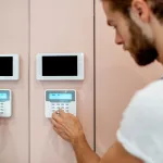 Workman setting up the alarm with keyboard near the entrance at home